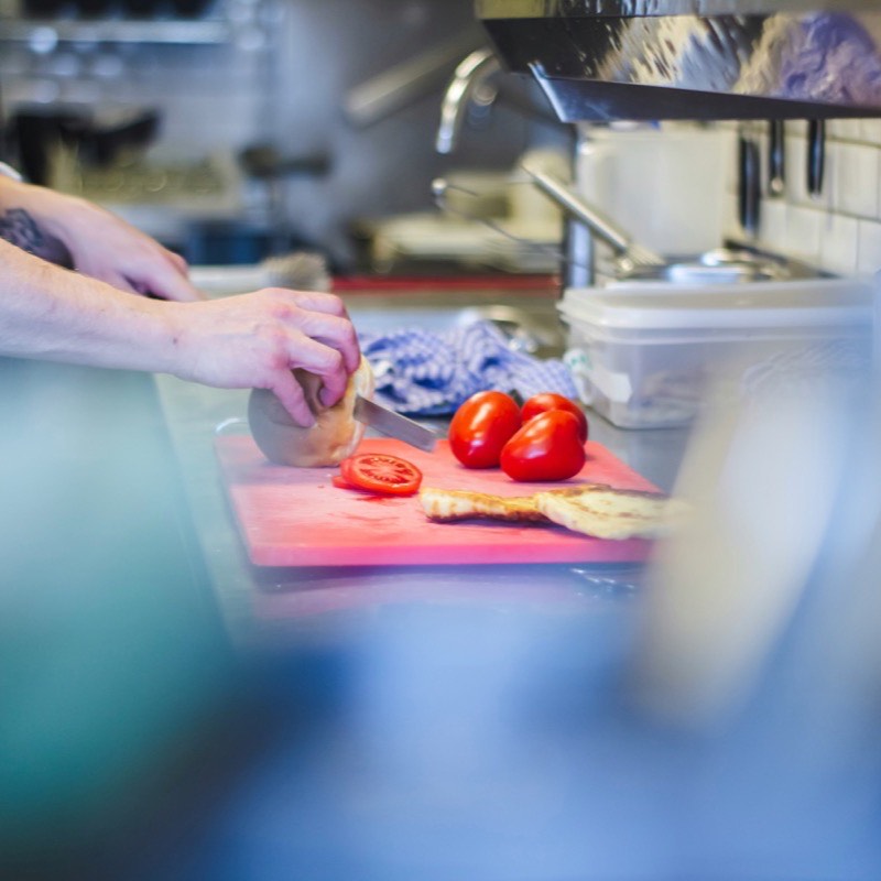 Person schneidet Tomaten