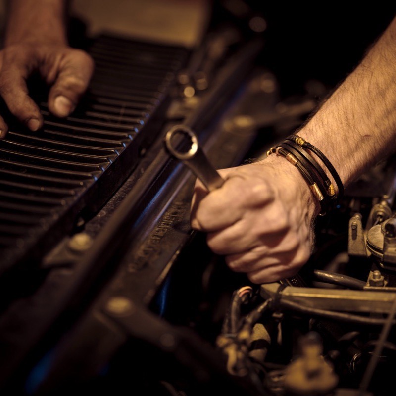 Hände arbeiten am Automotor